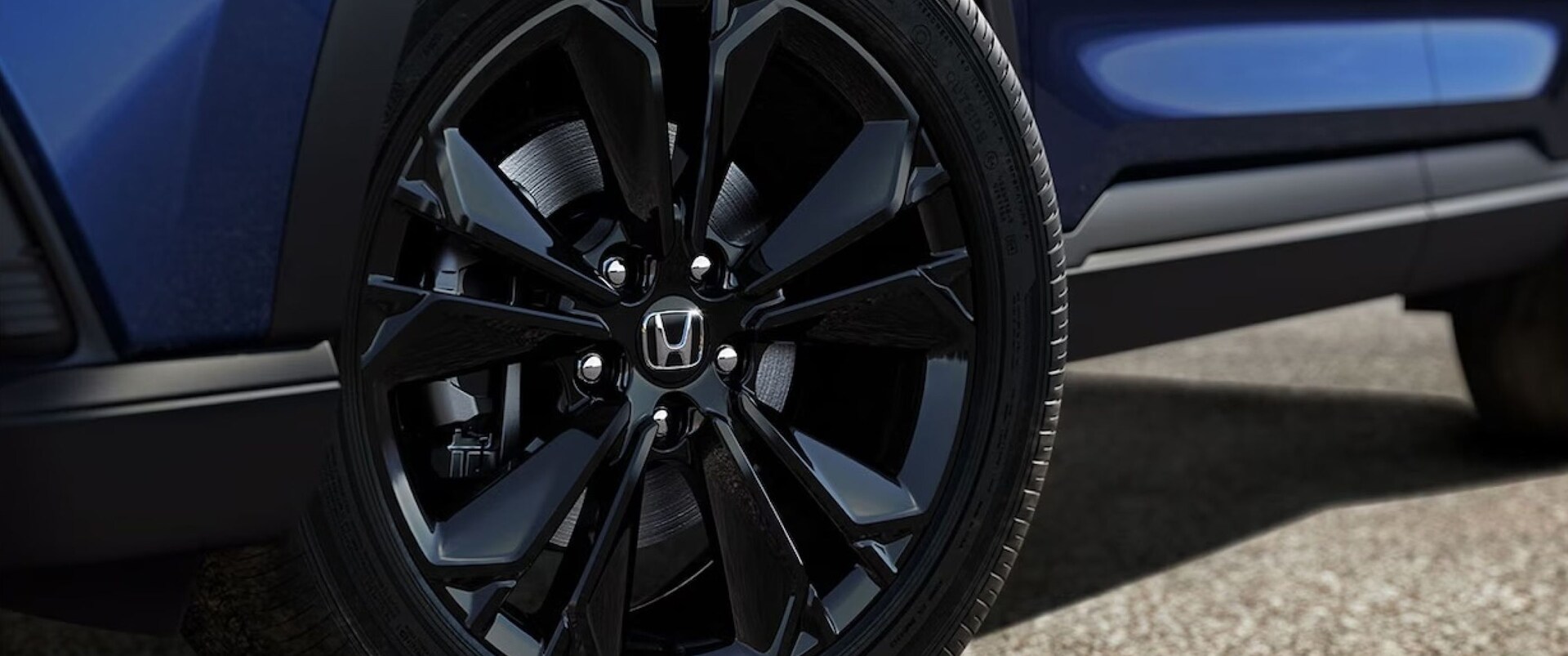Black rim and tire on a blue 2026 Honda CR-V
