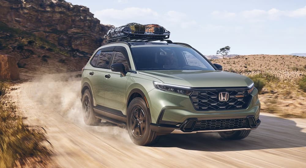 A green 2026 Honda CR-V TrailSport off-roading on a trail
