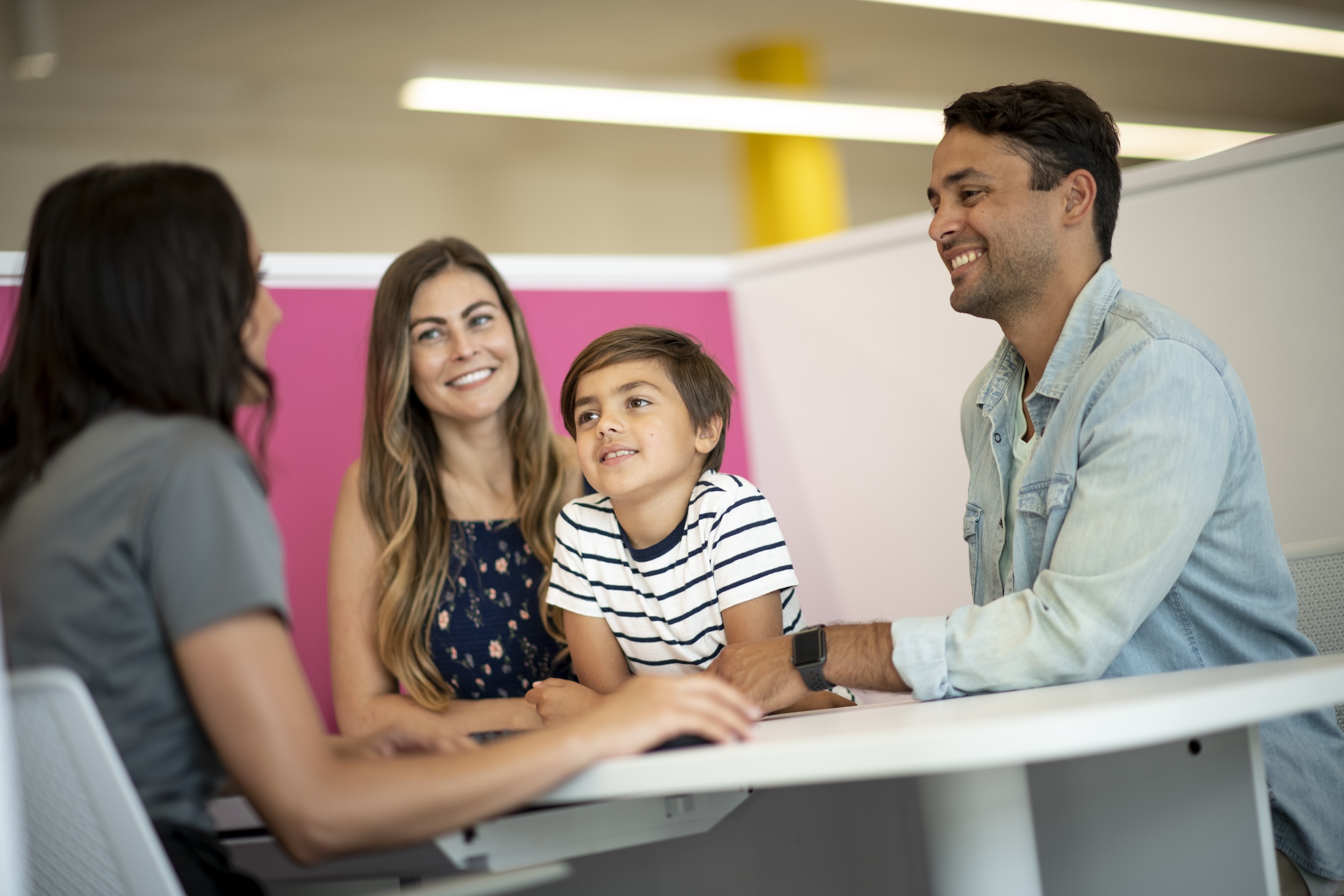 Family smiling with Carshop associate at table