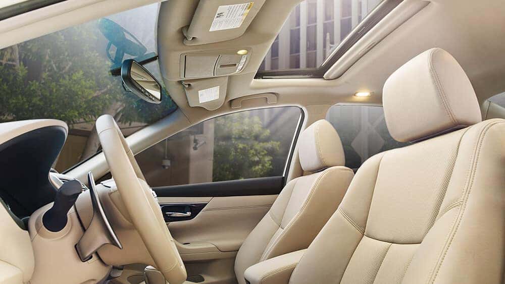 2017 Nissan Altima beige leather front seats seen through the open rear door
