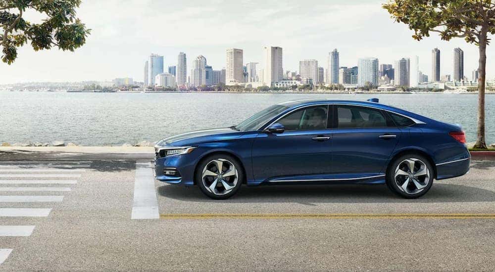 A blue 2022 Honda Accord is shown from the side leaving a Rochester used Honda dealer.