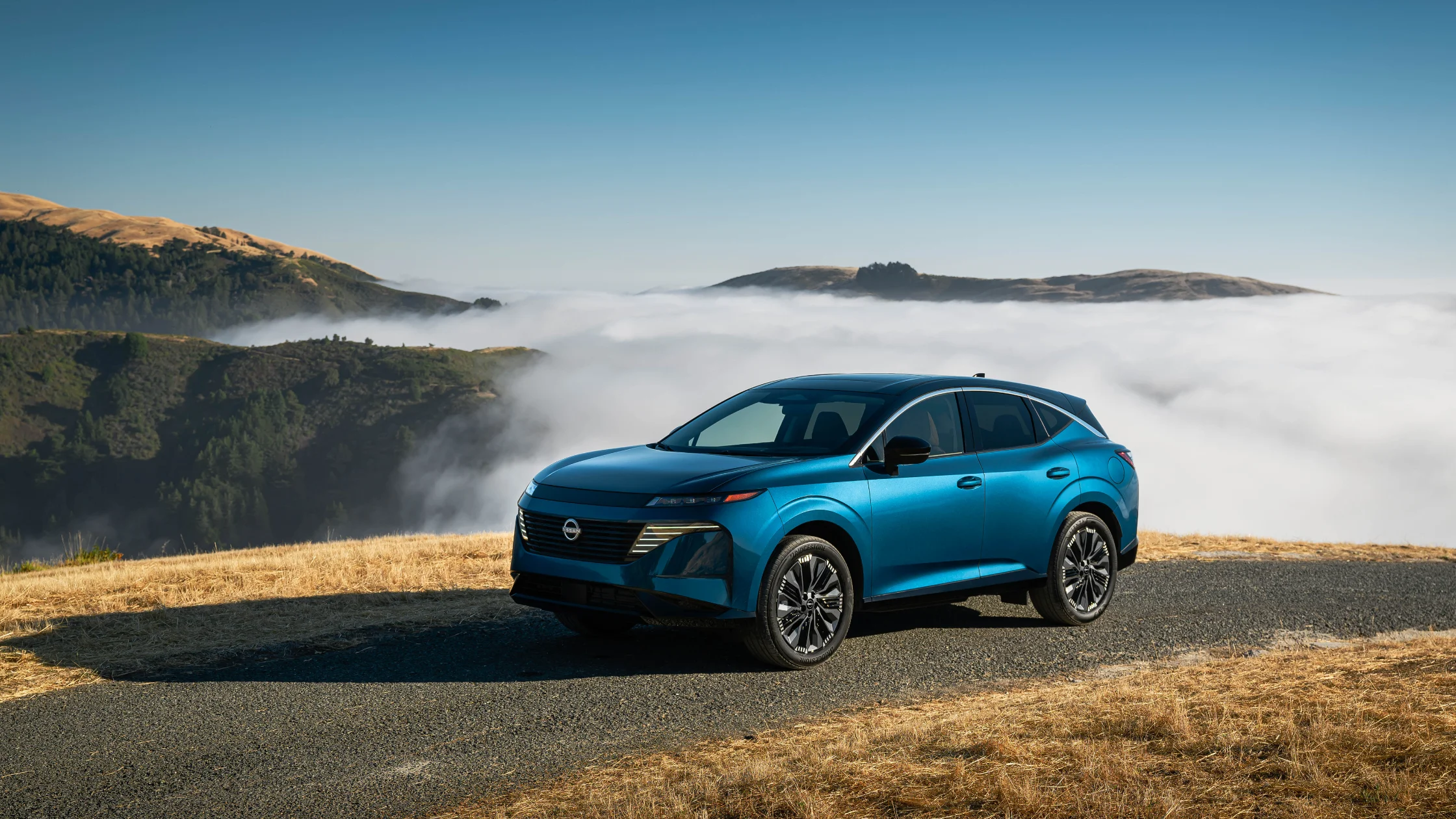 2026 Nissan Murano® blue SUV parked on a mountain overlook above low clouds