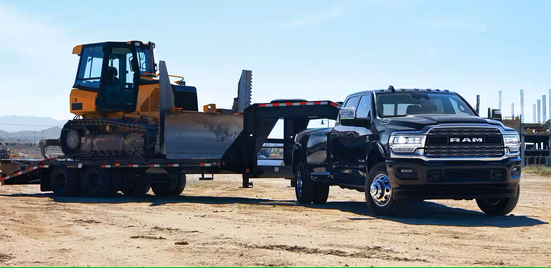 A black truck parked with a trailer .