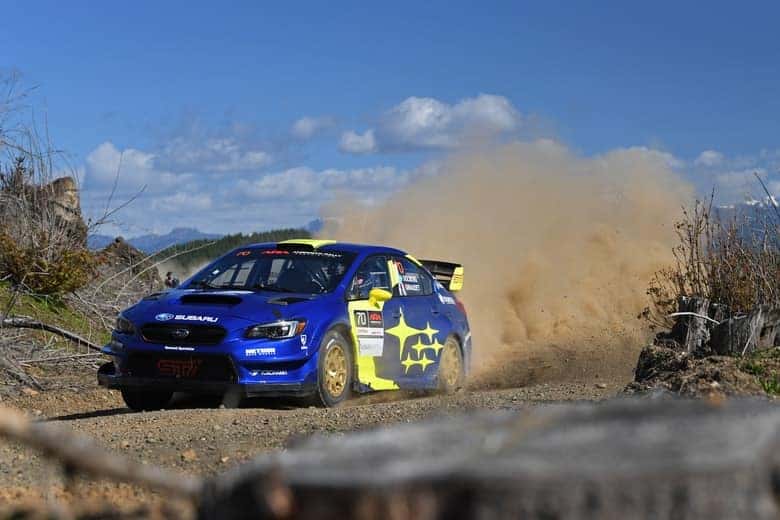 Blue Subaru WRX rally car kicking up dust