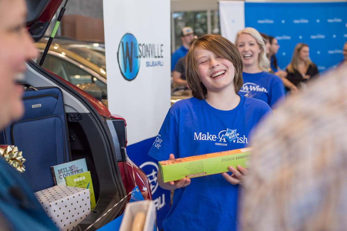 Danton smiling while holding a golden ticket at the dealership