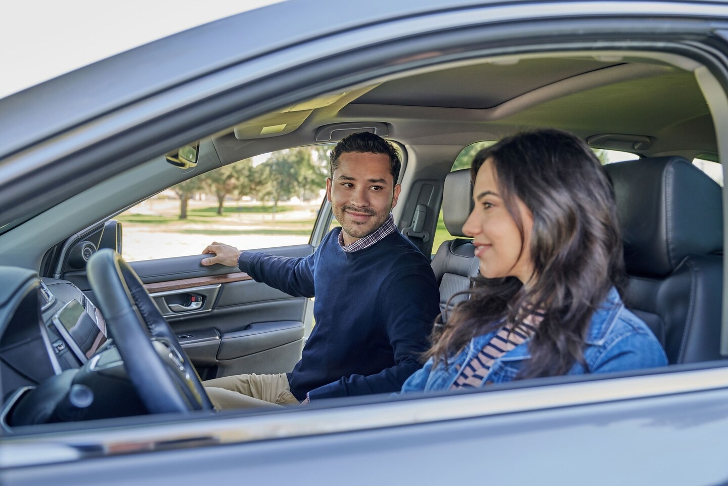 Couple sitting in a car at the dealership