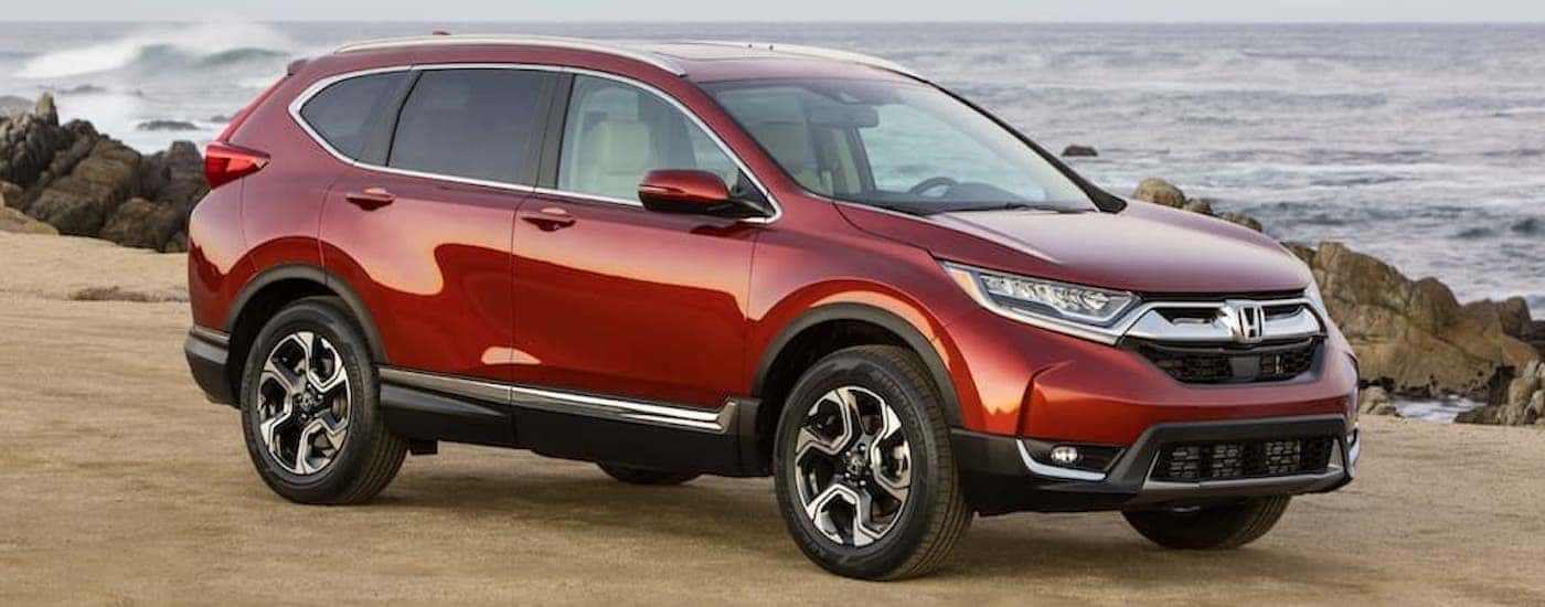 A red 2017 Honda CR-V is shown parked near an ocean.