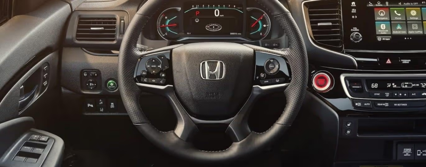Steering wheel and controls are shown in a 2021 Honda Passport Elite