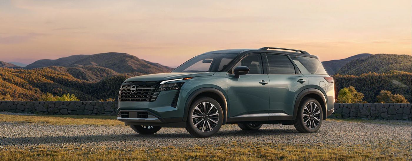Green 2026 Nissan Pathfinder parked on a gravel trail.