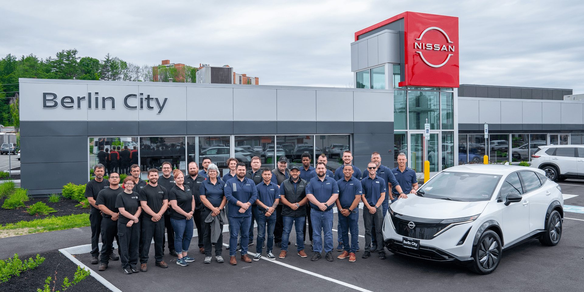 staff at Berlin City Nissan of Portland standing outside dealership entrance
