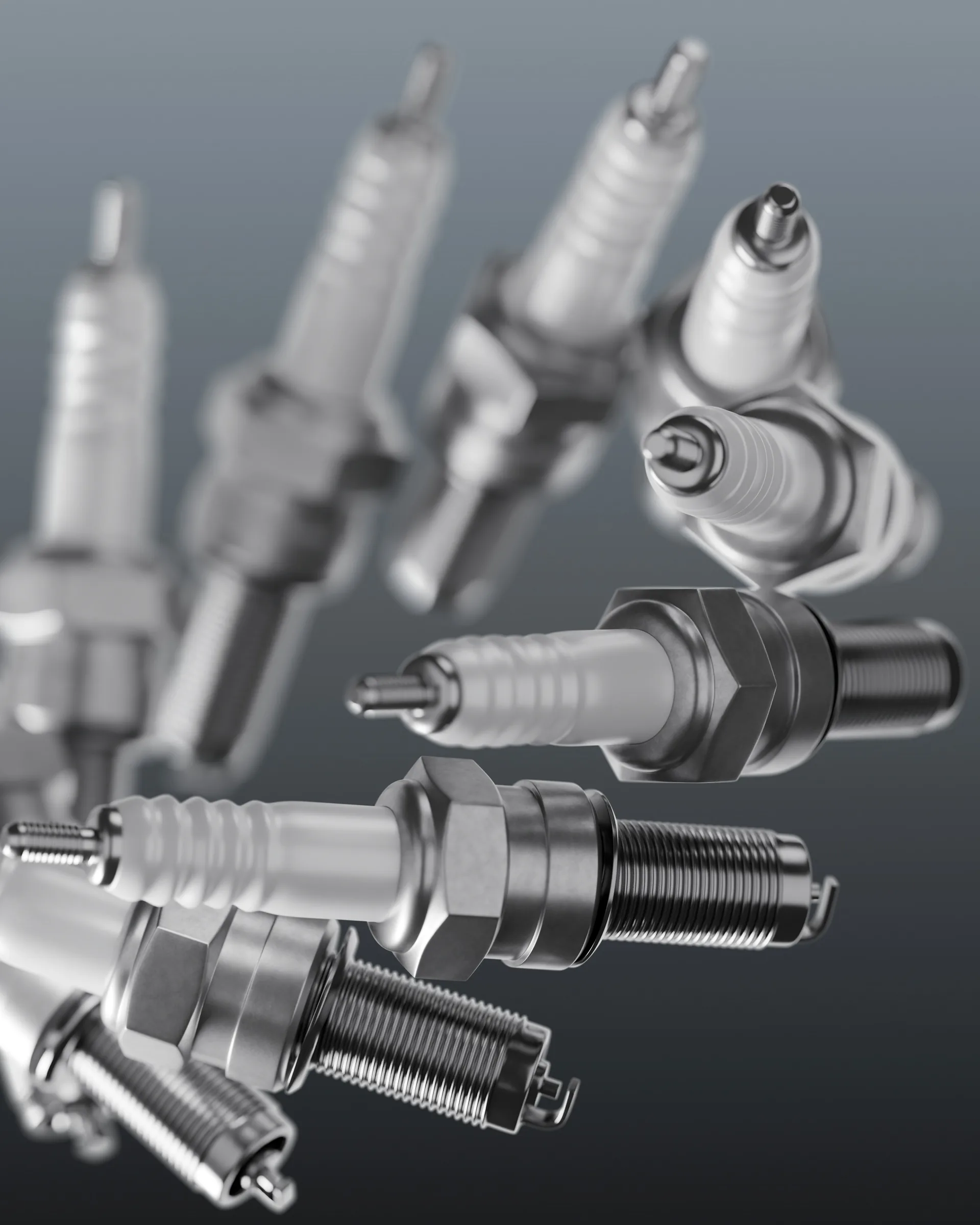 Close-up rendering of several metallic spark plugs arranged at angles against a dark gray background. Spark Plugs Service Near Topeka, KS