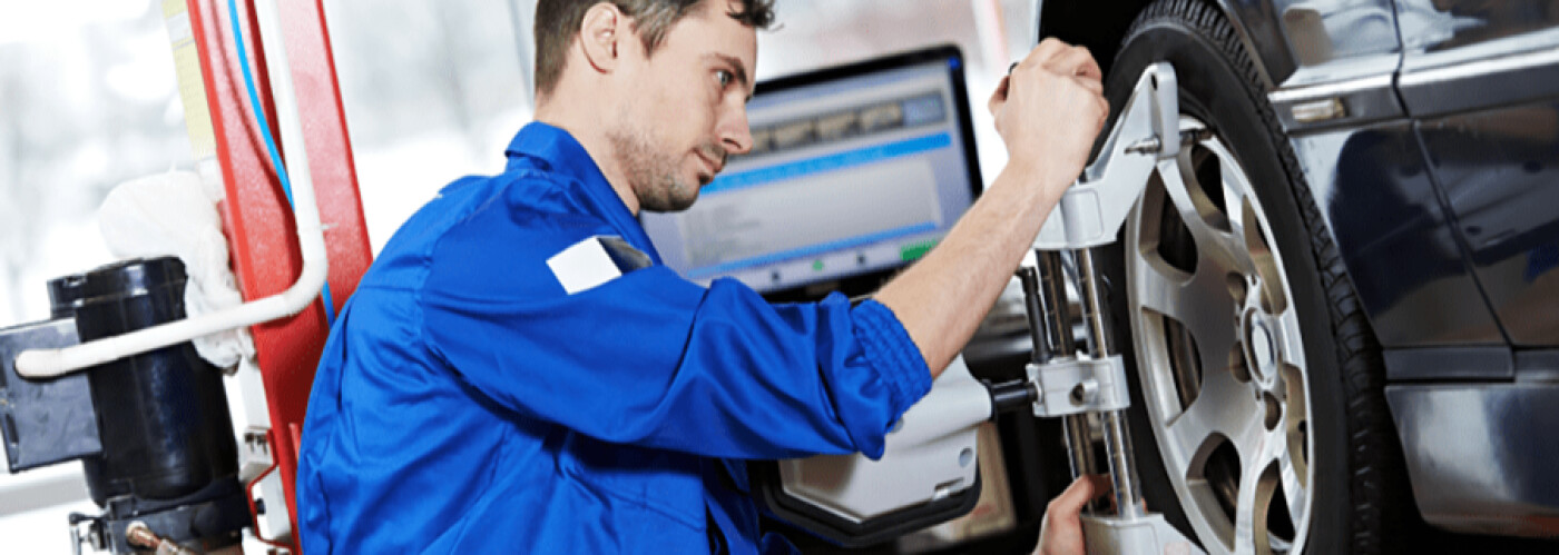 mechanic performs wheel alignment