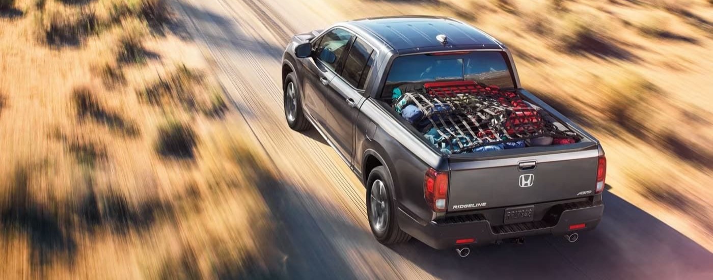 Grey 2022 Honda Ridgeline driving on a trail