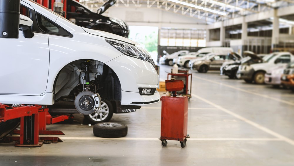 white car on mechanic lift in a shop