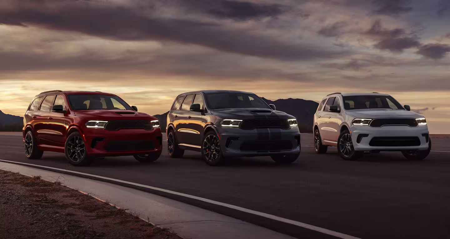 a lineup of suvs at sunset on a blacktop road