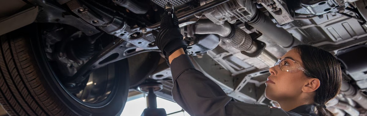 2024 Chevy Service Center Technician Performing Oil Filter Change Under Vehicle