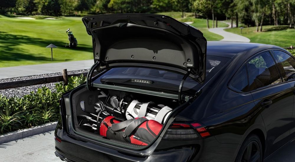 The open cargo area on a black 2026 Honda Accord Hybrid parked at a golf course.