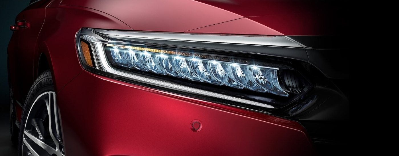 Close up of the passenger side headlight on a red 2021 Honda Accord