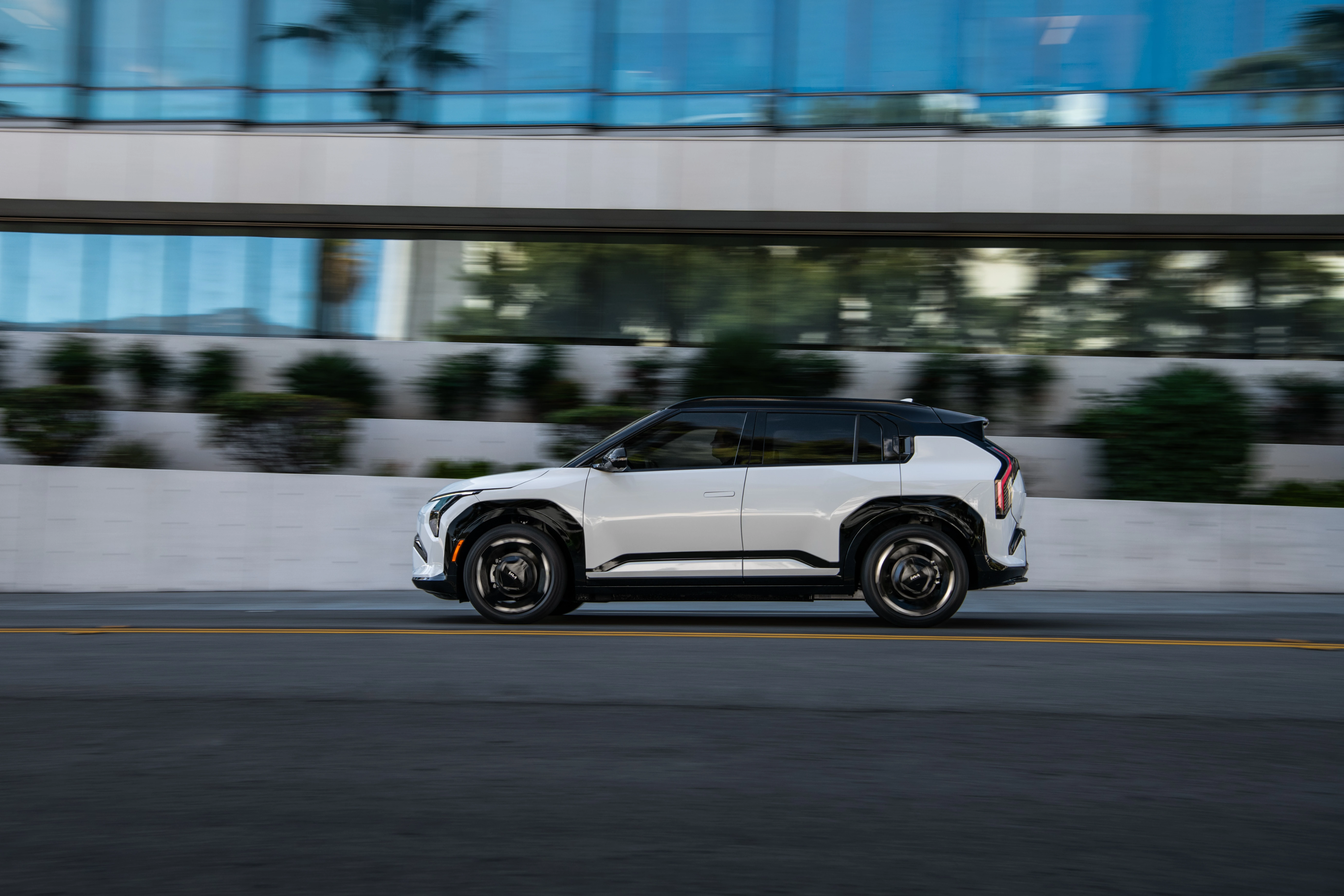 Side profile of a white 2027 Kia EV3 in motion