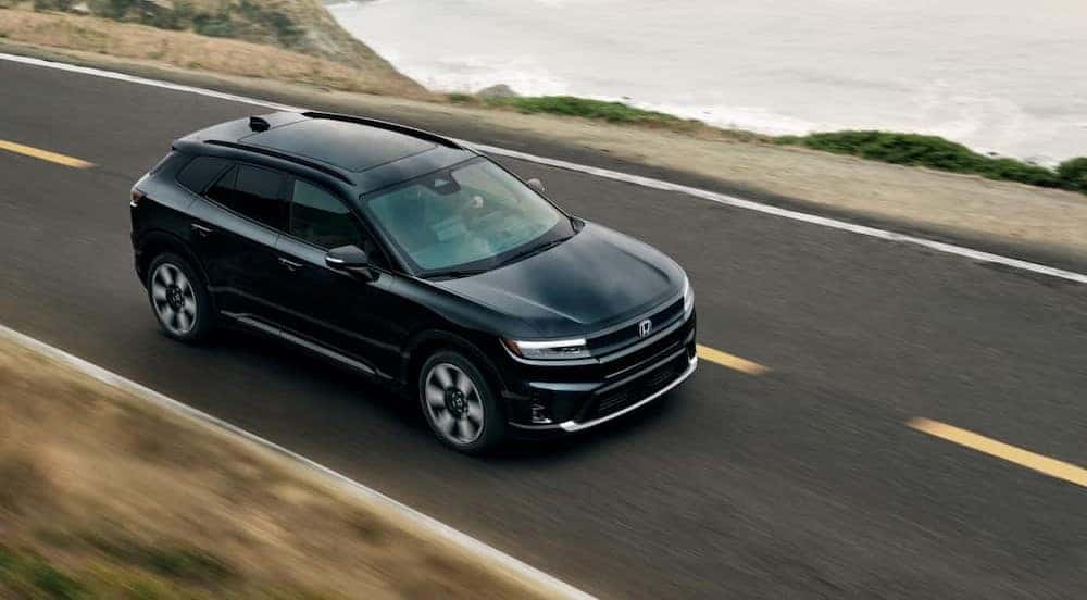 A black 2025 Honda Prologue driving on a highway.