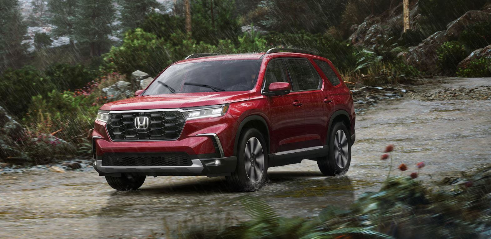 red 2025 Honda Pilot Elite, driving on a gravel road in the rain