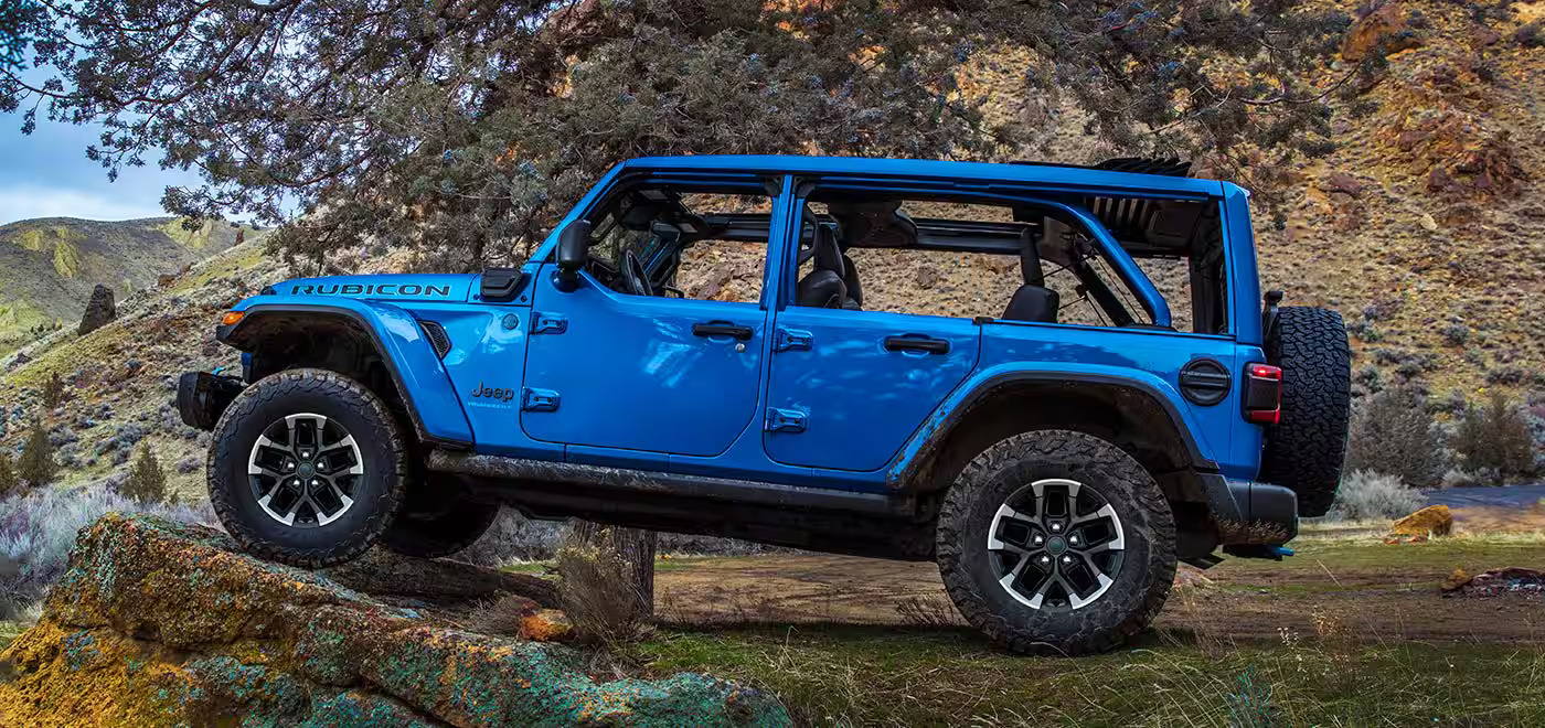 a blue hybrid suv driving in the woods