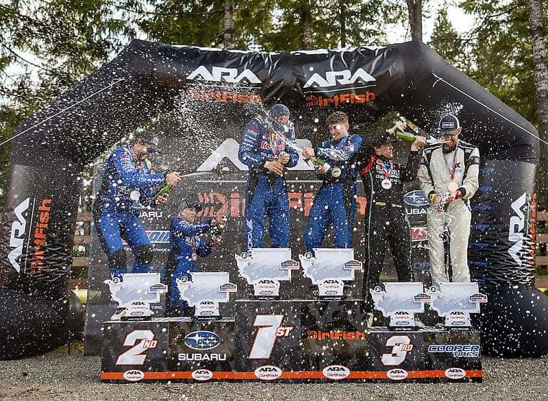 Subaru rally drivers celebrating on the podium