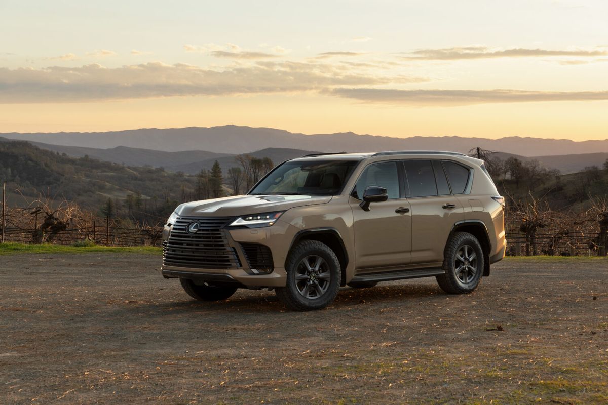 2026 Lexus LX 700h Overtrail in Earth color with all-terrain tires, parked on dirt at sunset