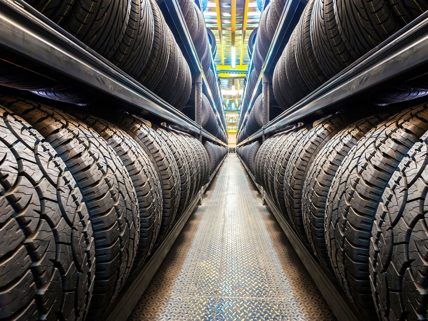 Rows of new tires stacked on warehouse shelves