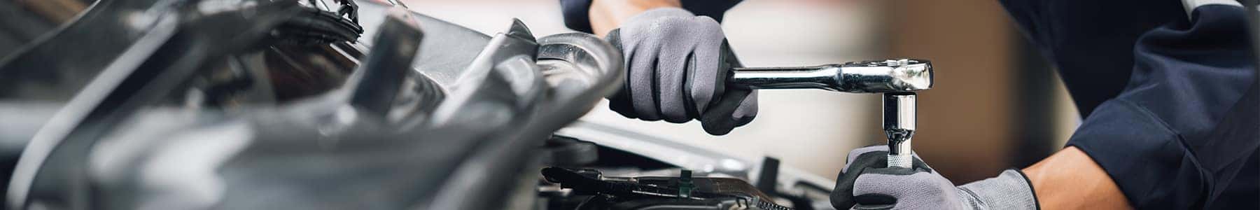 Technician tightening an engine bolt with a ratchet wrench