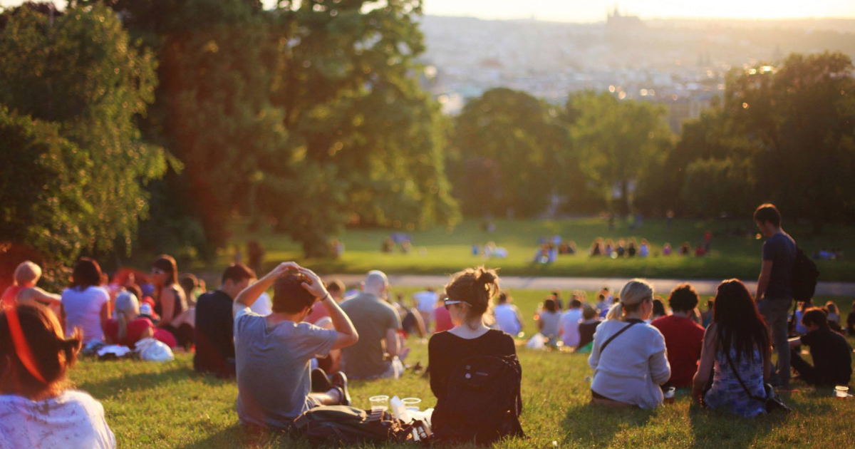 People sitting on a hill in a park