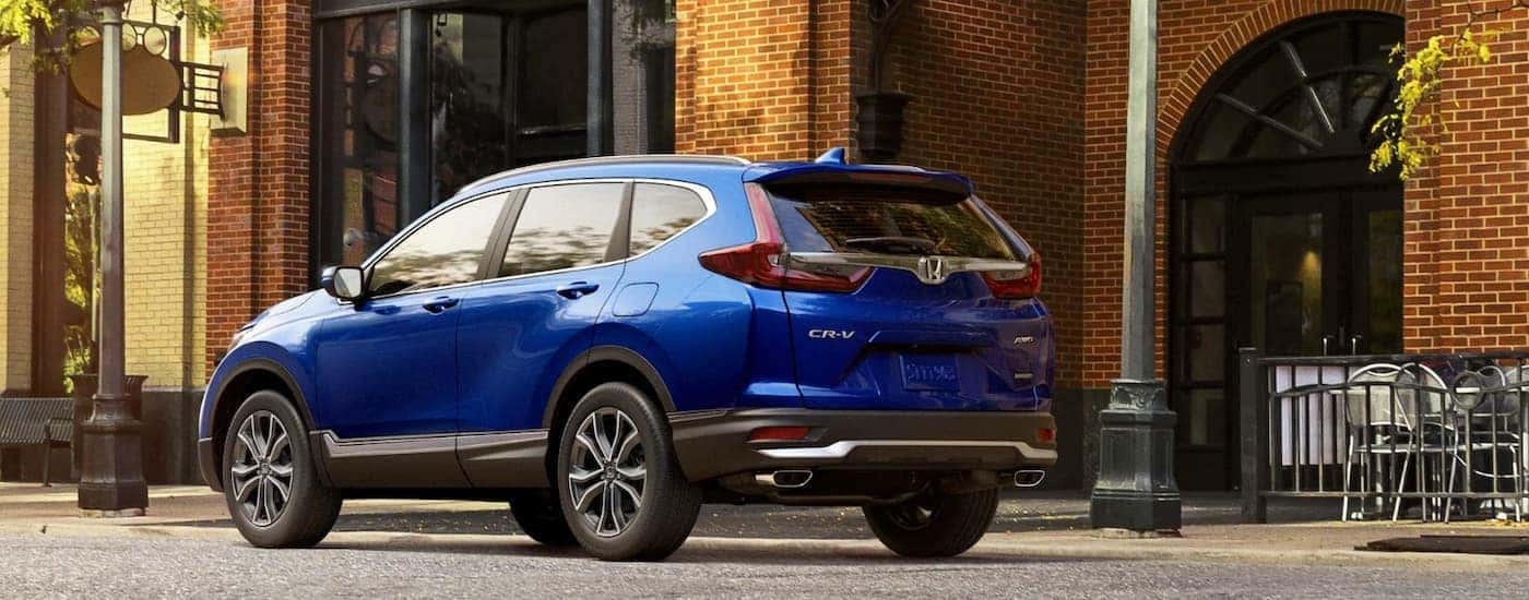 A blue 2020 Honda CR-V is shown parked near a brick building.