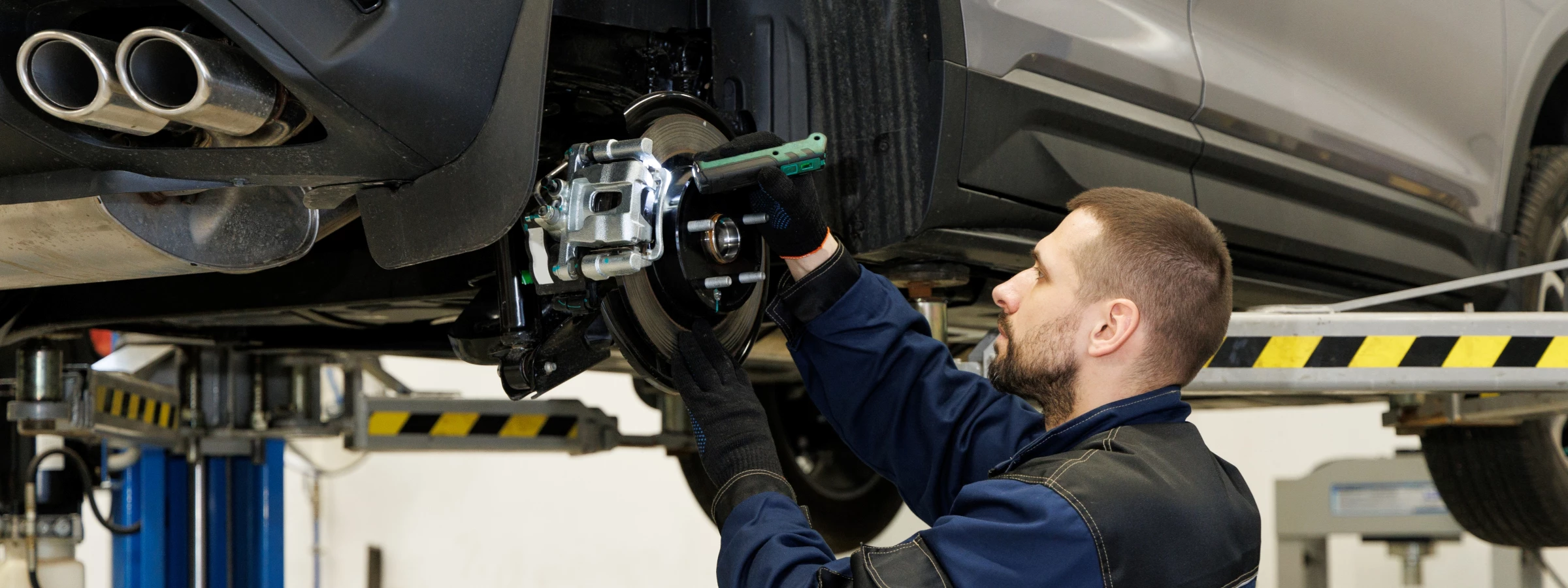 Mechanic repairing a car's suspension on a lift