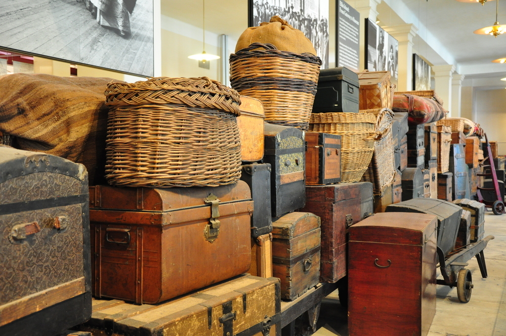 A large amount of luggage is seen in a museum, it is from the families that came to Ellis Island from the years 1892-1954