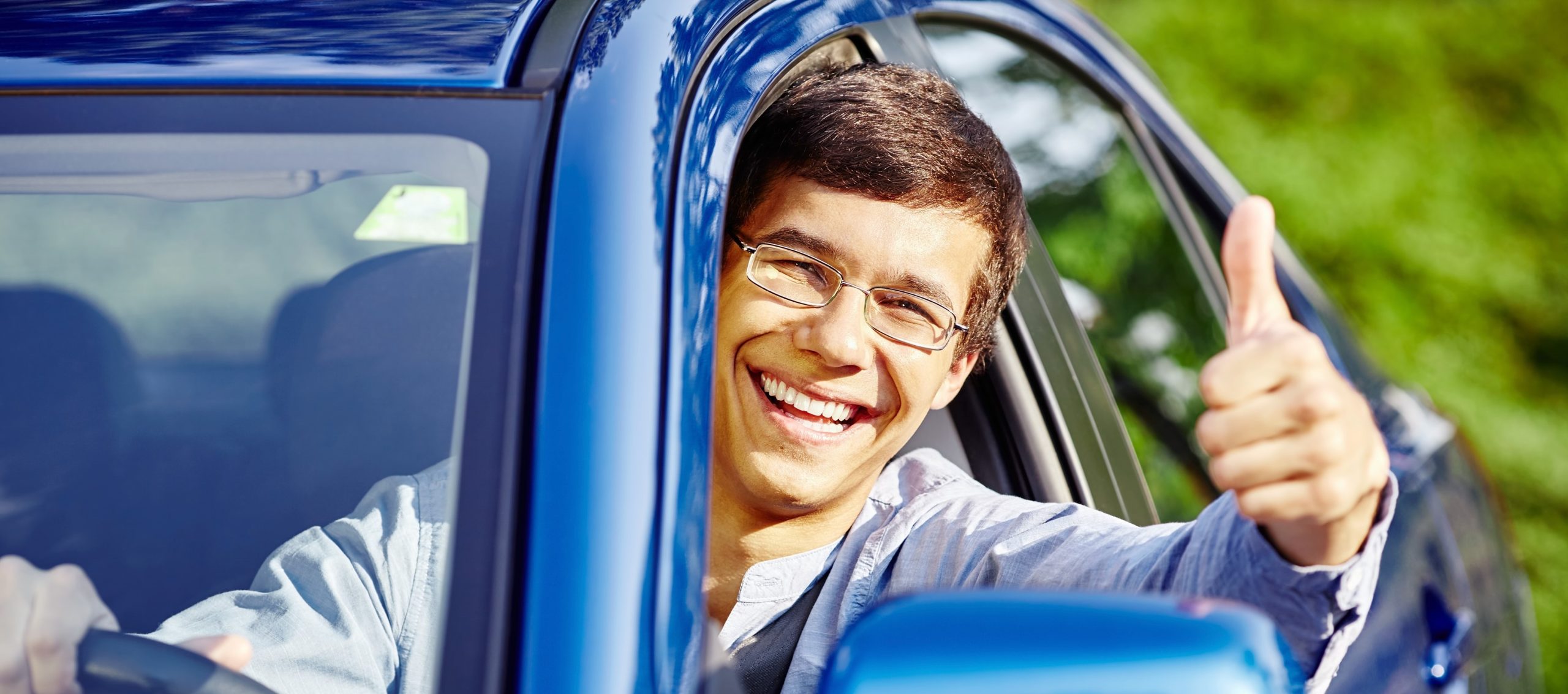 teen driving blue car