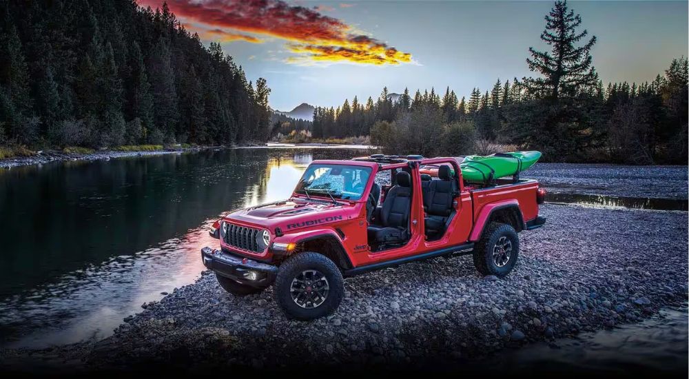 A red 2024 Jeep Gladiator Rubicon is shown near a lake.