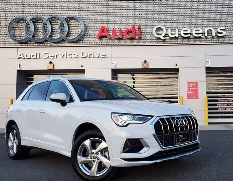 A white Audi parked at the Audi Queens service drive entrance in Flushing