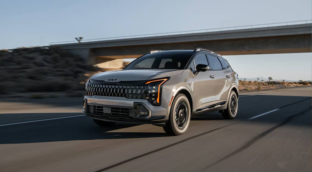 Grey 2026 Kia Sportage driving off-road.