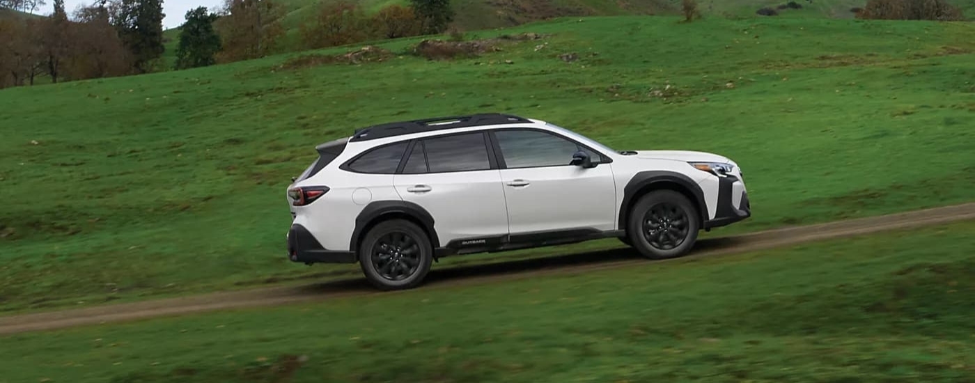 A white 2023 Subaru Outback Onyx driving.