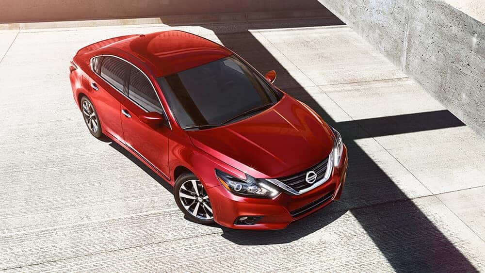 Red 2017 Nissan Altima sedan parked on a sunlit concrete plaza, viewed from above