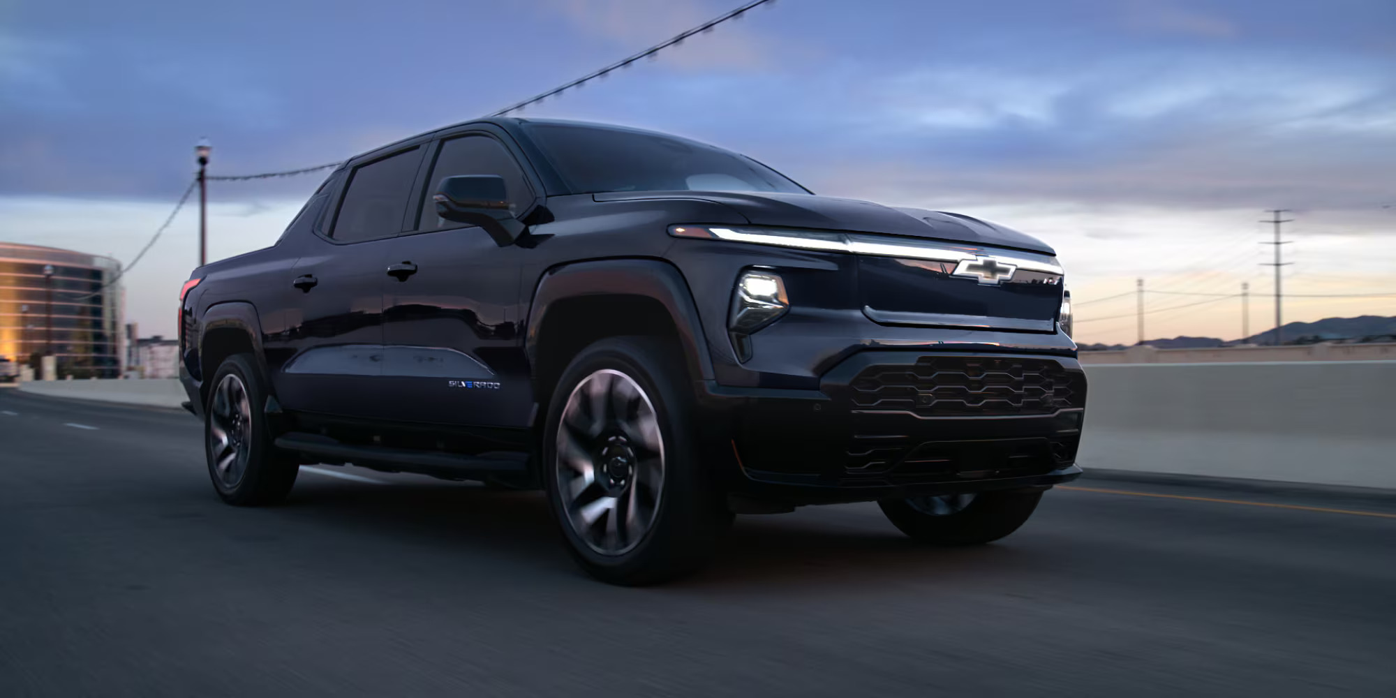 A black truck driving on the road.