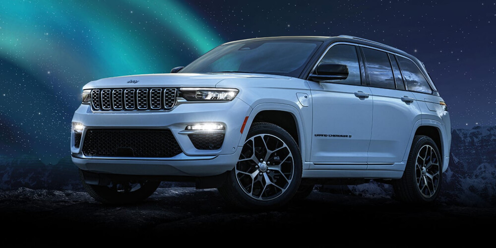 2024 Jeep Grand Cherokee 4xe parked on hill with aurora sky background
