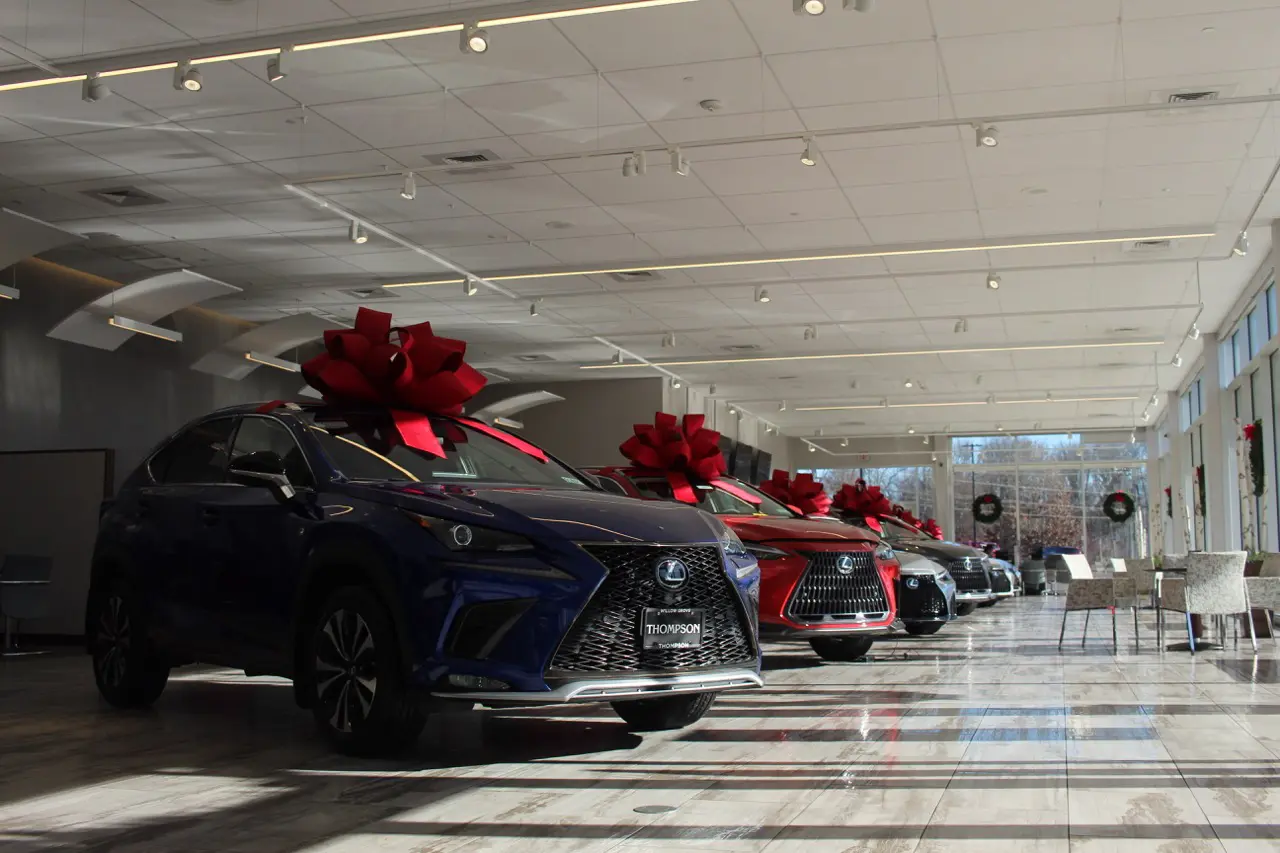 Row of luxury Lexus SUVs parked at a Philadelphia-area dealership lot at sunset.
