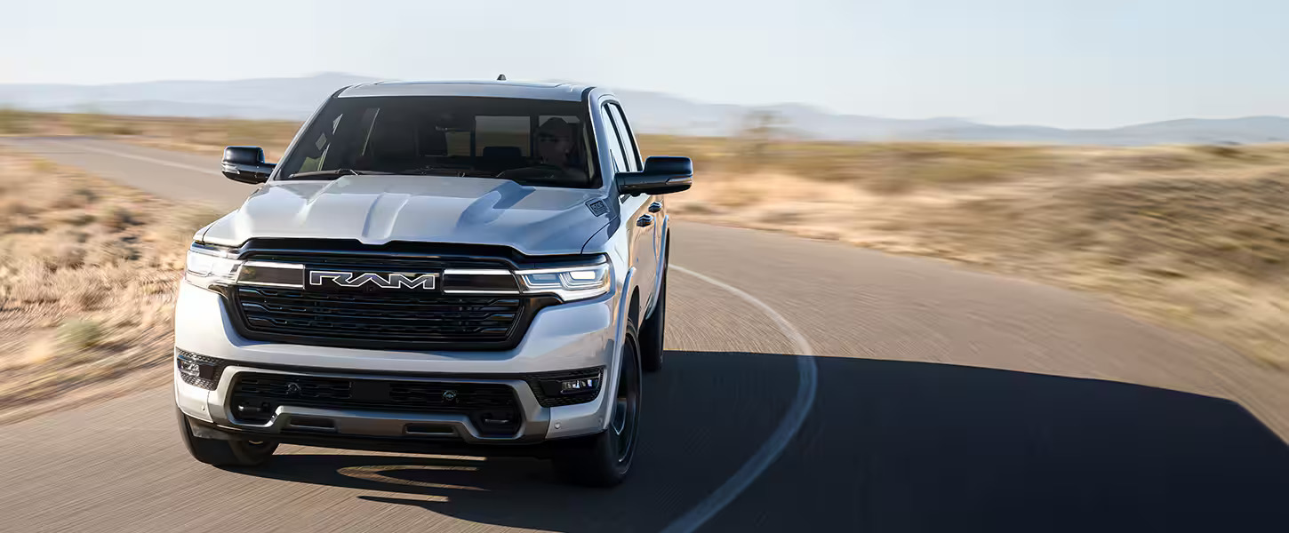 A silver truck driving on a road.