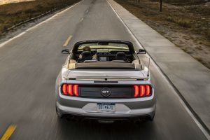 rear view of a silver 2019 Ford Mustang GT driving along a coastal highway