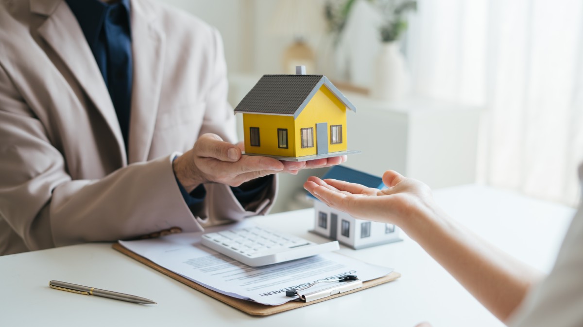 Model House Being Passed Representing Home Insurance