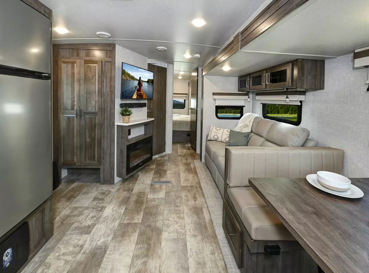 Rockwood Ultra Lite Travel Trailer 2608BS view from dining area to bedroom in back- image highlights the Autumn Wood Cabinetry that gives warm, homey feel