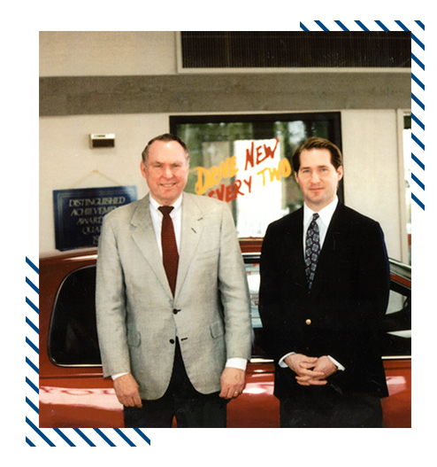 Dos hombres de pie frente a un coche, foto vintage




