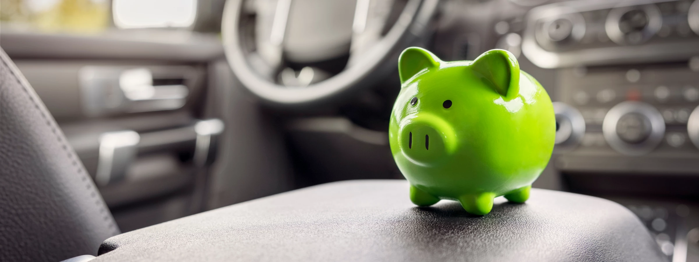 Green piggy bank on a car's center console