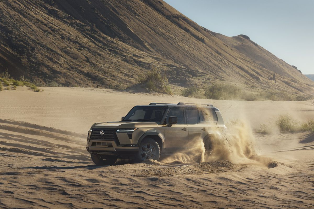 2026 Lexus GX front three-quarter exterior kicking up dust off-road